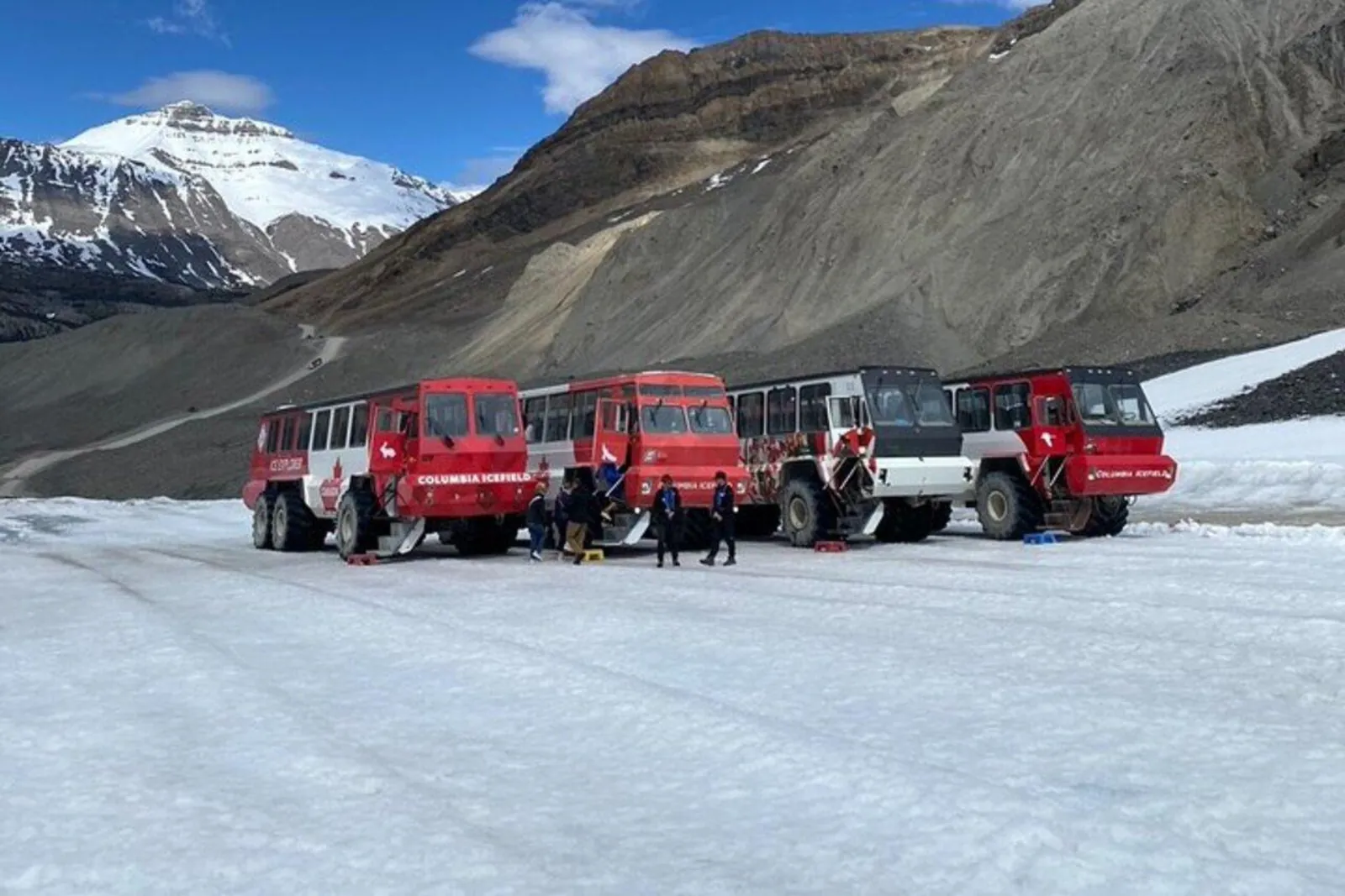 Four Ice Explorers parked on the glacier below the moraine access road